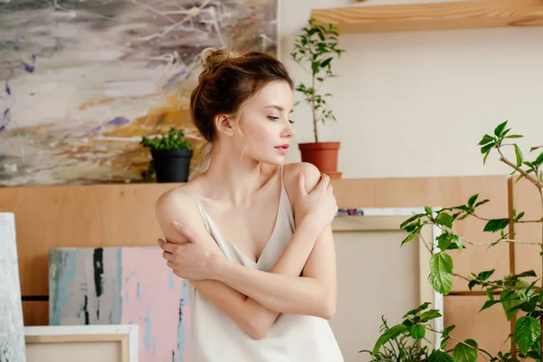 Bella tenera giovane donna guardando lontano in studio d'arte — Foto stock