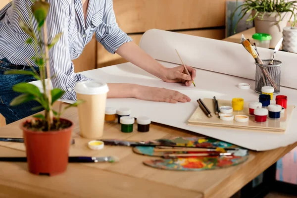 Cropped shot of young female artist drawing on table in studio — Stock Photo