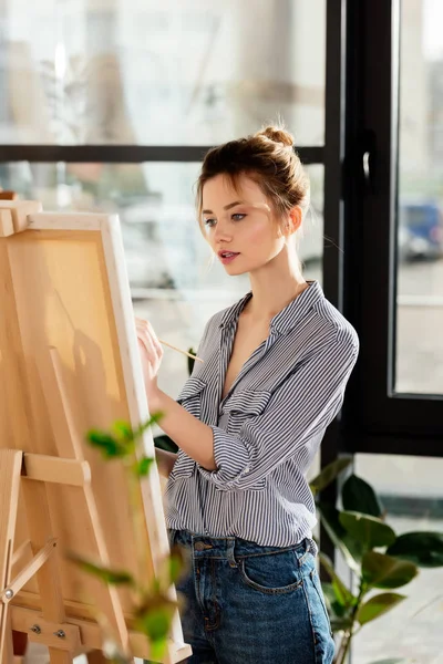 Junge attraktive Künstlerin zeichnet Bild im Atelier — Stockfoto
