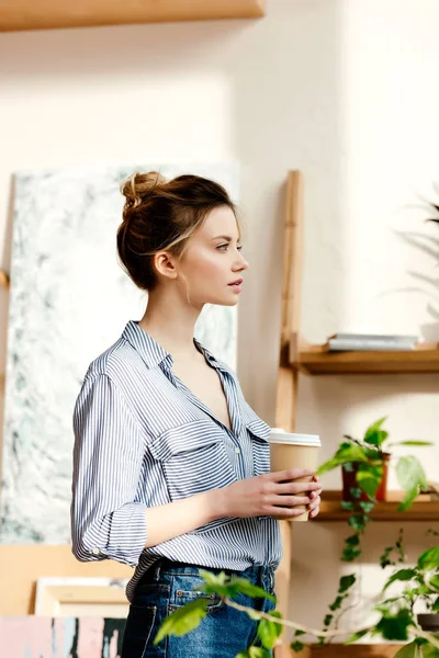 Side view of young woman with coffee cup in hands — Stock Photo