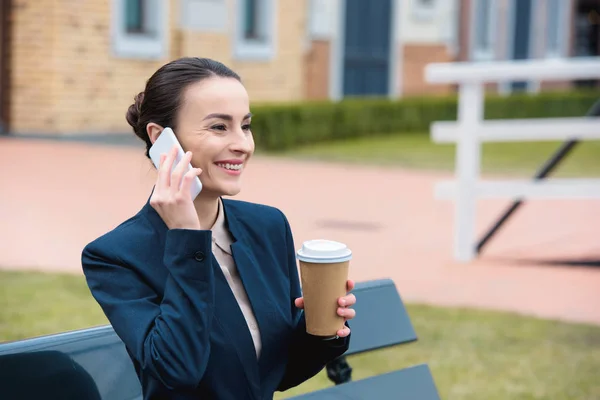 Красива бізнес-леді розмовляє по смартфону на лавці — стокове фото