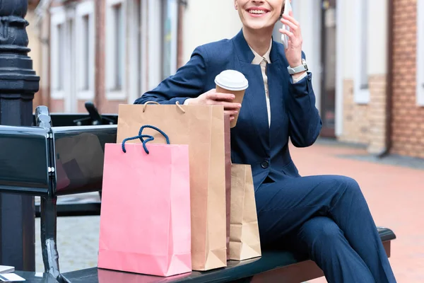 Immagine ritagliata di donna d'affari che parla da smartphone dopo lo shopping — Foto stock