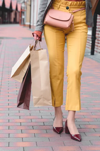 Imagen recortada de la mujer caminando con bolsas de compras - foto de stock
