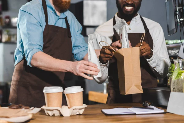 Imagem cortada de proprietários de café colocando ordem em saco de papel — Fotografia de Stock