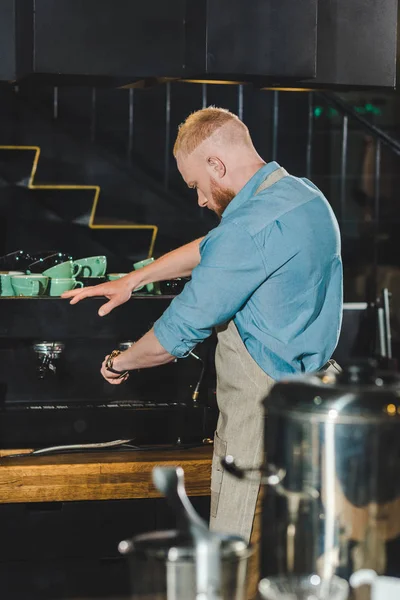 Vista trasera de barista macho joven con máquina de café - foto de stock