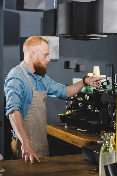 Seitenansicht eines jungen männlichen Baristas, der auf einem digitalen Tablet Ordnung schafft — Stockfoto