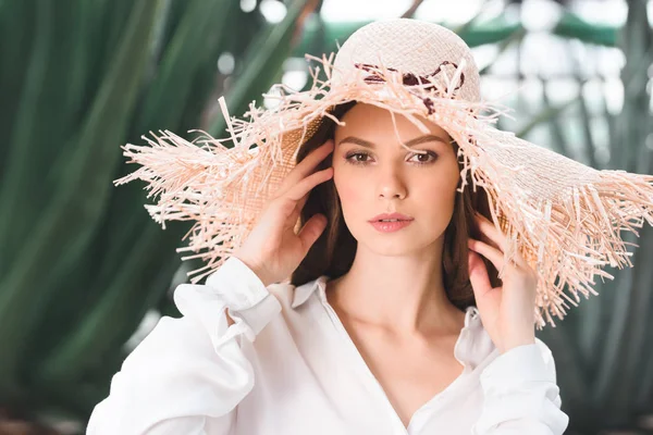 Bela jovem mulher em chapéu de palha posando no jardim tropical — Fotografia de Stock