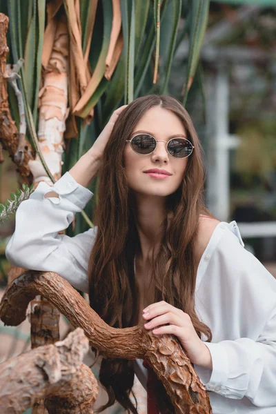 Beautiful girl in trendy sunglasses posing on tropical resort — Stock Photo