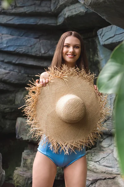 Beautiful smiling woman in straw hat in tropical garden — Stock Photo