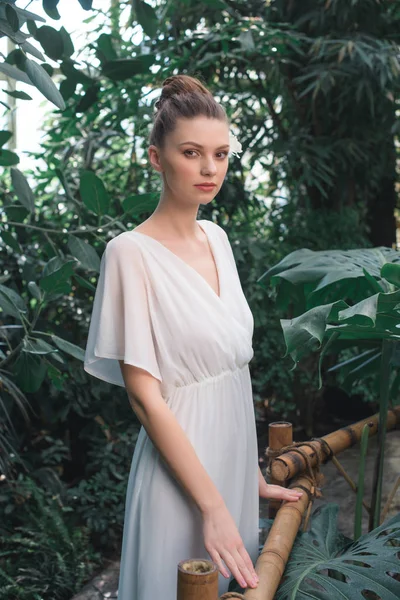 Attraktive Frau im weißen Kleid posiert im tropischen Garten — Stockfoto