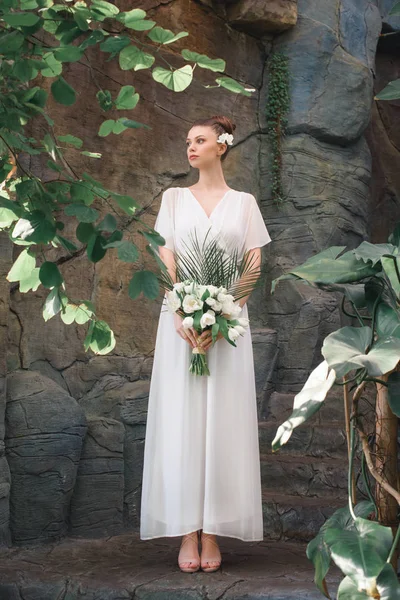 Beautiful bride posing in white dress with wedding bouquet — Stock Photo