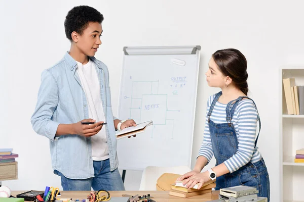 Multikulturelle Freunde besprechen Hausaufgaben zu Hause — Stockfoto