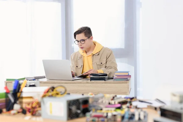 Teen boy using laptop and studying at home — Stock Photo