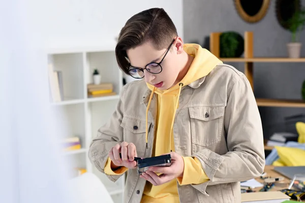 Adolescent garçon fixation circuit informatique dans salon — Photo de stock