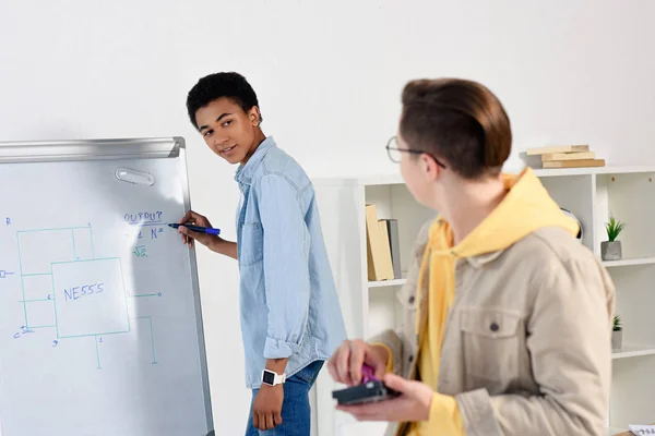 Multicultural teen boys studying and fixing computer circuit at home — Stock Photo