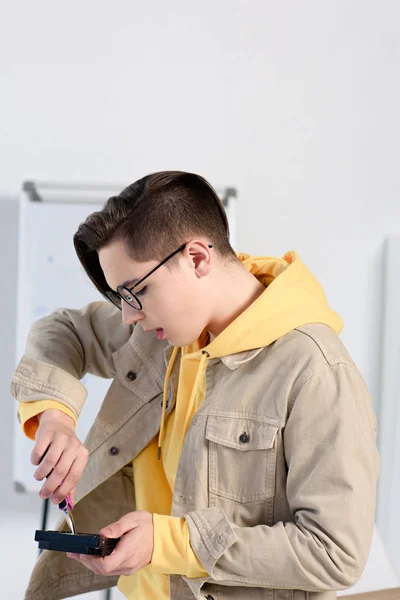 Мальчик-подросток чинит компьютерную цепь дома — стоковое фото