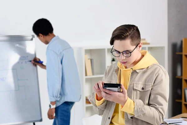 Multicultural teen boys studying and looking at computer circuit at home — Stock Photo