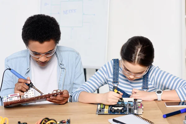 Multikulturelle Freunde löten Computermotherboard und reparierten Schaltung zu Hause — Stockfoto