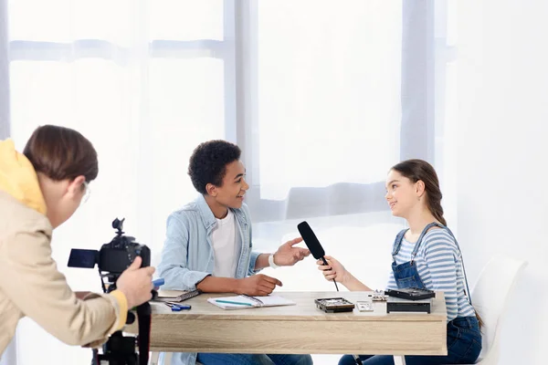 Caucasian teen kid conducting interview with african american friend for video blog — Stock Photo