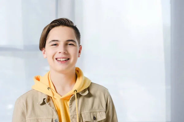 Портрет улыбающегося мальчика, смотрящего в камеру дома — стоковое фото
