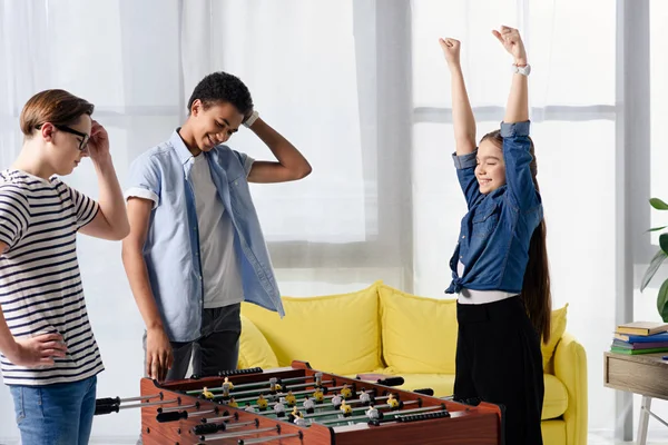 Happy teen kid winning table football at multicultural teenagers at home — Stock Photo