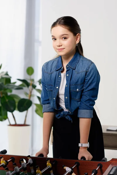 Adorable preteen child playing table football at home — Stock Photo