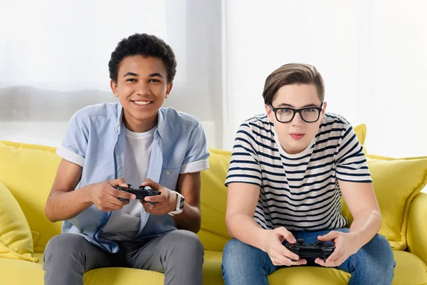 Happy multicultural teen boys playing video game at home — Stock Photo