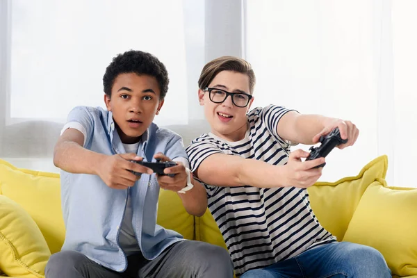 Multicultural teen boys playing video game at home — Stock Photo