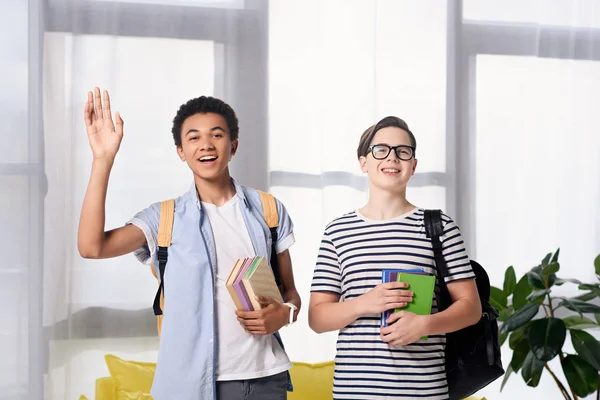 Adolescent multiculturel garçons saluant quelqu'un à la maison — Photo de stock