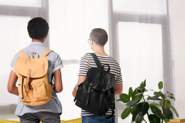 Back view of multicultural teen boys standing with bags at home — Stock Photo