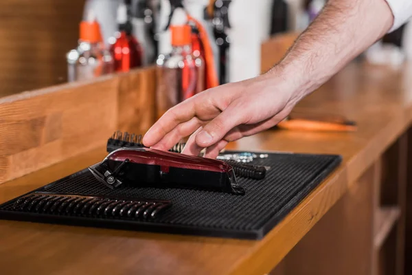 Cropped shot of barber choosing tools from rubber mat at workplace — Stock Photo