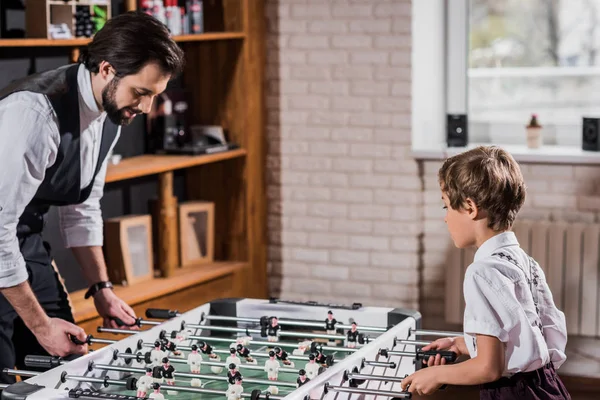 Bello barbuto padre e piccolo figlio giocare a calcio balilla — Foto stock