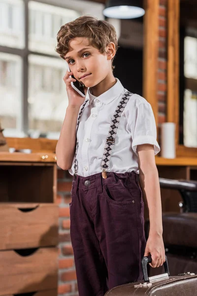 Adorable niño hablando por teléfono en la barbería - foto de stock