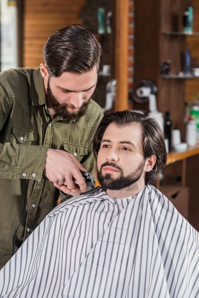 Cliente de afeitado peluquero con Hair Clipper en la barbería - foto de stock