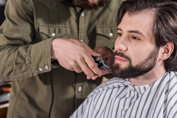 Recortado tiro de peluquero afeitado cliente con Hair Clipper - foto de stock