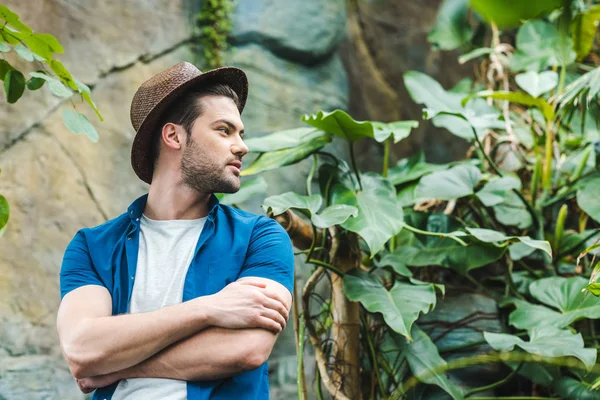 Junger Mann mit Strohhut und stylischer Kleidung im Regenwald — Stockfoto