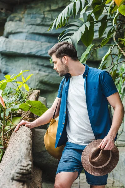 Jovem atraente em roupas elegantes com chapéu de palha na floresta tropical — Fotografia de Stock