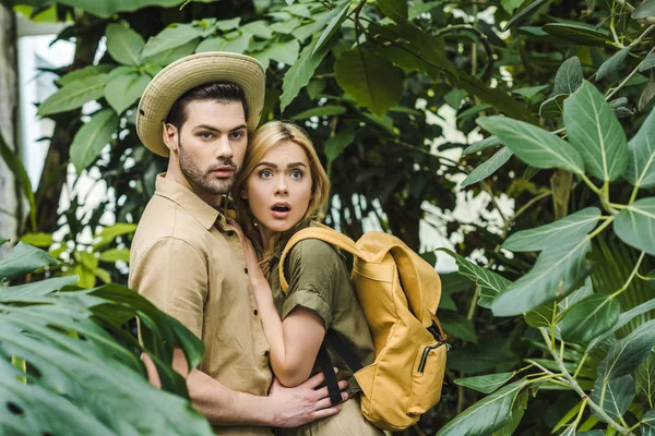 Pareja joven asustada en trajes de safari en la selva - foto de stock