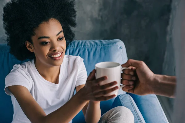 Hombre dando taza de café a chica afroamericana - foto de stock