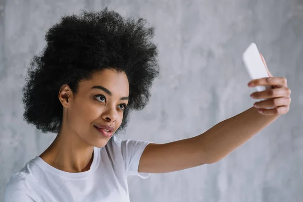 Atractiva mujer afroamericana tomando selfie con teléfono - foto de stock