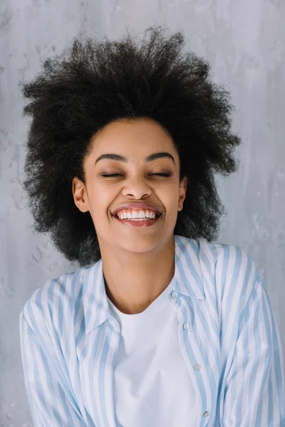 Feliz chica afroamericana sonriente sobre fondo gris de la pared - foto de stock