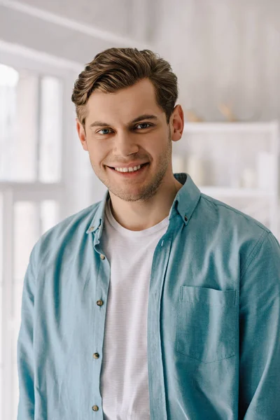 Hombre sonriente usando ropa de salón en casa - foto de stock