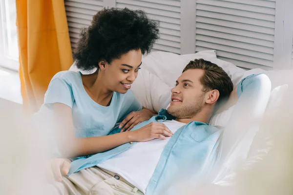 Pareja joven descansando en la cama en casa - foto de stock