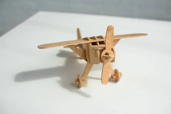 Vista de cerca del avión de juguete de madera en la mesa blanca - foto de stock