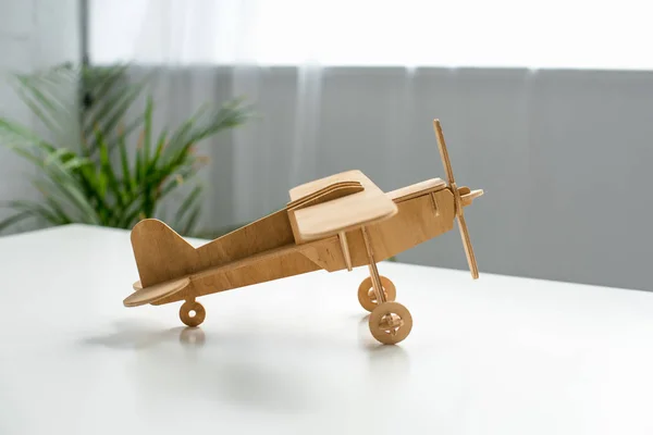 Close up view of wooden toy plane on white tabletop — Stock Photo