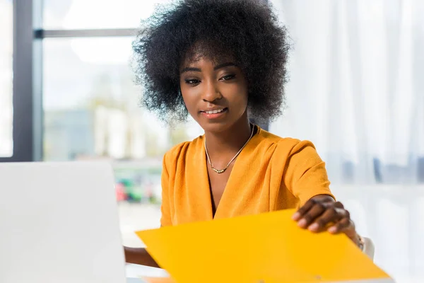 Sonriente afroamericano freelancer en el lugar de trabajo en casa - foto de stock