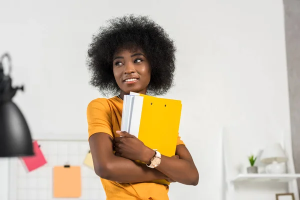 Portrait of young smiling freelancer with folders in hands at home — Stock Photo