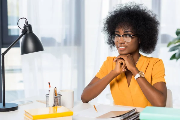 Retrato do sorridente freelancer afro-americano em óculos no local de trabalho em home office — Fotografia de Stock