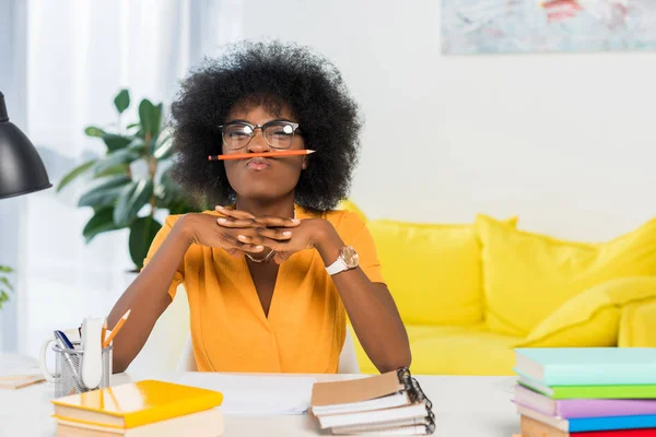 Portrait of african american freelancer in eyeglasses with pencil at workplace at home office — Stock Photo
