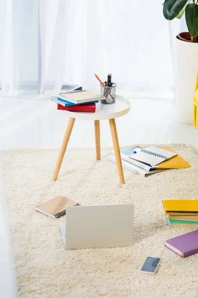 Close up view of laptop, notebooks and folders arranged on floor at home office — Stock Photo